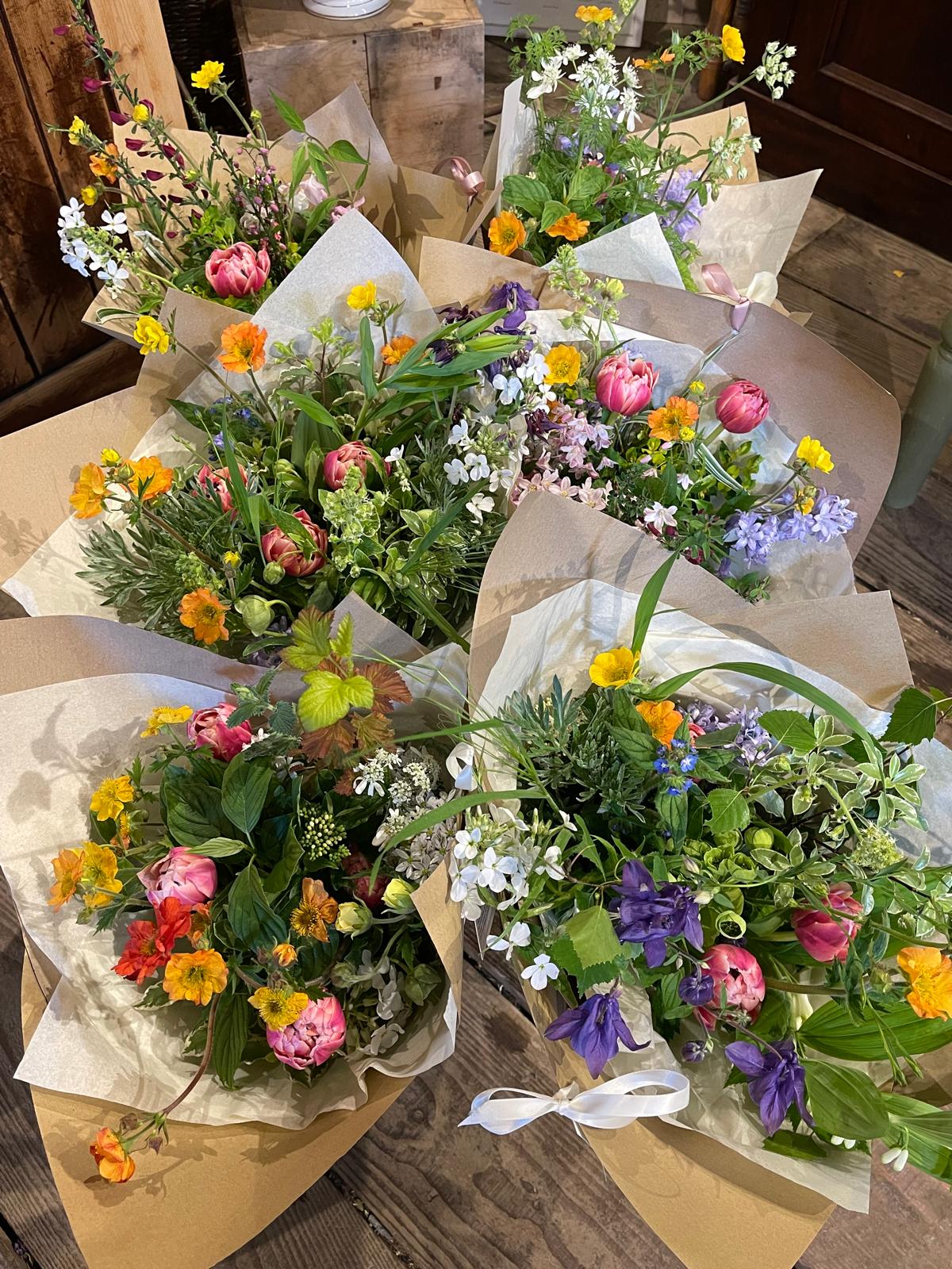 A collection of freshly arranged floral bouquets with a variety of flowers, wrapped in sustainable packaging.